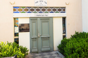 Petah Tikva, Israel, 12  JUNE 2025, The facade of The Great Synagogue, A Jewish Synagogue Building With A Green Door And Hebrew Inscriptions.