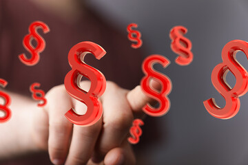 Red paragraph symbols floating, hand interacting. Legal concept, law, justice, regulation.