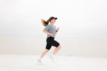 Dynamic Runner Enjoying a Brisk Jog on a Cloudy Day in an Urban Setting, Capturing the Essence of...