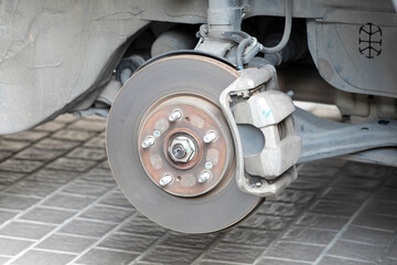 Rusty disc brake with caliper in process of tire replacement