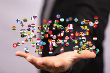 Diverse flags floating above a hand, symbolizing international connections and global reach.