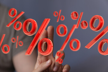 Red percentage symbols floating around a hand, illustrating discounts, interest rates, or financial...