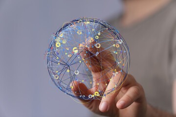 Hand holding a digital globe, illustrating interconnected data points and global networks.