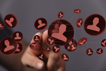 Image depicts a hand interacting with a network of interconnected profiles, representing social...
