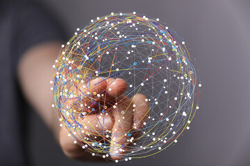 Abstract image depicting a hand interacting with a digital sphere representing global network...