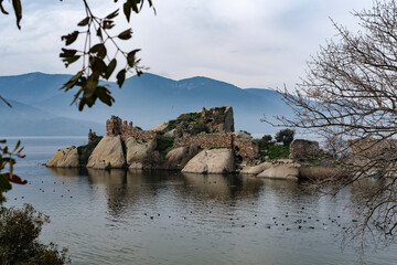 small island with historical ruins at Bafa Lake, dry tree, volcanic rock formation on waterfront