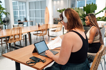Young man uses smartphone and laptop simultaneously, depicting multitasking and digital efficiency...