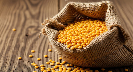Yellow Lentils in Burlap Sack on Wooden Background