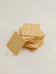 Square crackers piled on white background