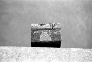 Cracked wooden block on concrete surface with blurry water background