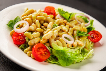 Bean salad green leaf lettuce, tomato, onion vegetables dish fresh delicious gourmet food background on the table rustic food top view copy space keto and paleo diet vegan and vegetarian food