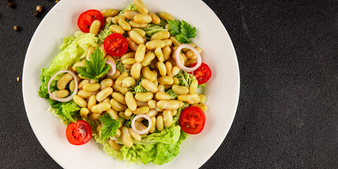 Bean salad green leaf lettuce, tomato, onion vegetables dish fresh delicious gourmet food background on the table rustic food top view copy space keto and paleo diet vegan and vegetarian food