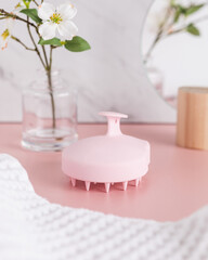 Pink silicone scalp massager in trendy bathroom