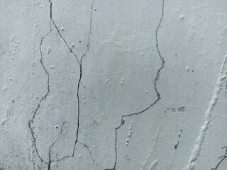 Cracked White Wall Surface Texture. Close-up of cracked and weathered white wall surface. Ideal for...