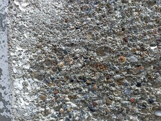 Rough Exposed Aggregate Concrete Texture. Close-up of rough exposed aggregate concrete wall with...