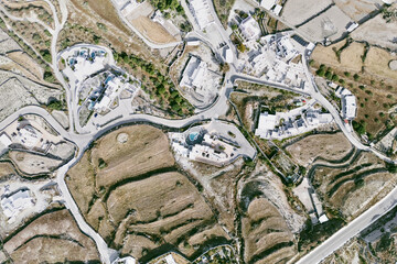 Aerial view of Santorini terrain from drone, volcanic landscape and deep blue sea