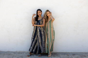 Models posing in summer clothes on a white wall.