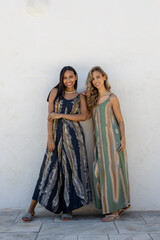Models posing in summer clothes on a white wall.