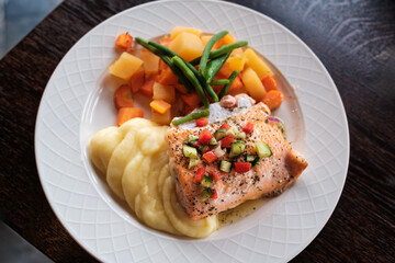 Delicious grilled salmon meal with mashed potato and vegetables