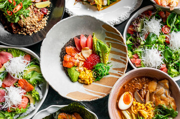 A vibrant selection of fresh dishes, including salmon poke bowls, ramen, and salads with avocado,...