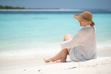 woman relax on summer resort, woman smiling while lying on sandy beach wearing a straw hat and white shirt, bright sunny tropical atmosphere in maldives, island vacation, summer happiness