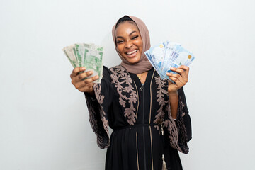 excited and happy african muslim lady holding some money