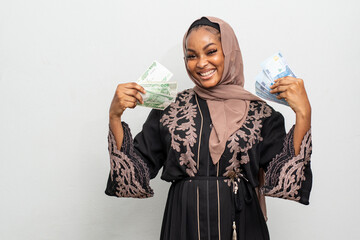 excited young black muslim woman flaunting some cash