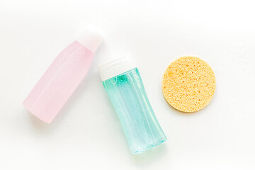 facial tonic, lotion and sponge for face care on white background top view mock up