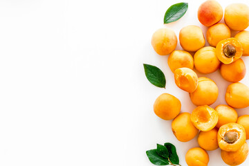 Fruit frame. Apricots and leaves on white background top view copy space