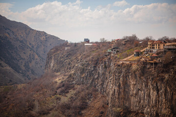 Village houses on cliff edge overlooking deep canyon in Armenia