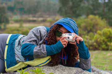 Photographer laying down taking pictures in the rain with analog camera.Photography day