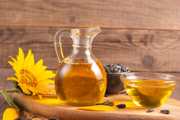 Sunflower oil and sunflower seeds on traditional rustic wooden background. Organic and eco food concept. Healthy food and fats.