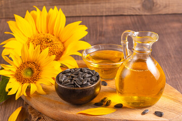 Sunflower oil and sunflower seeds on traditional rustic wooden background. Organic and eco food concept. Healthy food and fats.