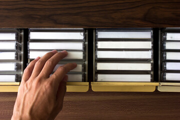 Selecting a tape cassette to play. The cassette tape has a plain white label and is blank with no label or writing, which can be used as a mockup or illustration.