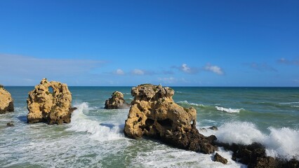 Panoramic scenic view of the ocean, caves, large rocks under the blue sky in Albufeira Portugal