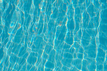 Crystal clear pool water surface with light patterns and reflections