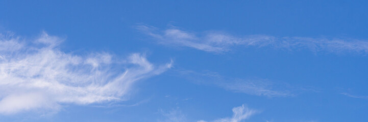 Clear blue sky with a few clouds. The sky is very bright and the clouds are scattered throughout