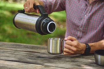 Pouring Hot Beverage Outdoors From Thermos Into Metal Mug