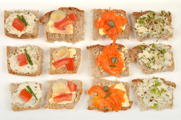 Open-faced vegan sandwiches with various creative spreads and toppings, arranged on a white tray