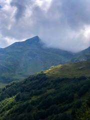 Fototapeta premium Clouds drifting over mountain peaks in Abkhazia, creating a dramatic and serene landscape