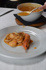 Serving Steaming Hot Sauce Over Delicious Seafood and Beans