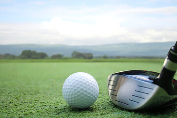 Golf Ball and Driver Club on Green Course Under Clear Sky