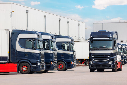 Fototapeta Modern blue cargo truck delivery van parked logistics warehouse center complex building exterior bay. Semi-trailer lorry unload goods distribution blue sky. Cargo storage facility industry building