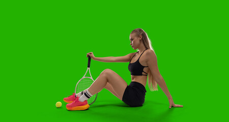 Woman tennis player playing tennis on green screen background.