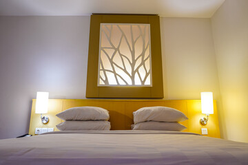 Comfortable Hotel Bed with Modern Headboard Design and Warm Lighting