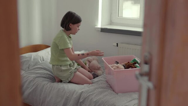 Child cleans up her toys.	
