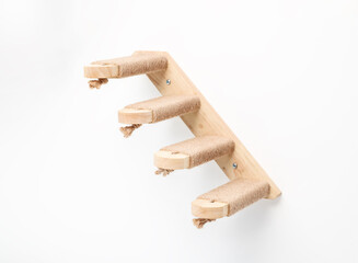 Cat climbing stairs or ladder on white wall. Wall-mounted cat steps with sisal or jute rope for...