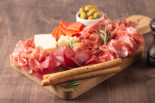 Charcuterie board. Antipasti appetizers of meat platter with salami, prosciutto crudo or jamon and olives.