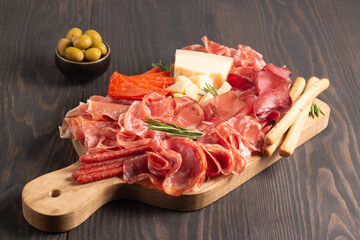 Charcuterie board. Antipasti appetizers of meat platter with salami, prosciutto crudo or jamon and...
