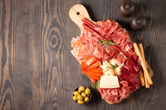 Charcuterie board. Antipasti appetizers of meat platter with salami, prosciutto crudo or jamon and olives.